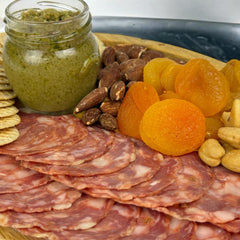 Angel’s Salumi and Truffles – Soppressata Piccante Salami Slices on Charcuterie Board with Cheese, Apricots, and Almonds