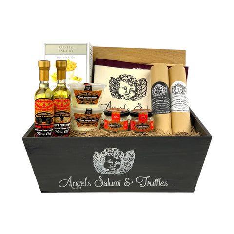 A dark wooden gift box filled with various antipasti and salami
