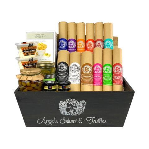 A dark wooden gift box filled with various antipasti and salami